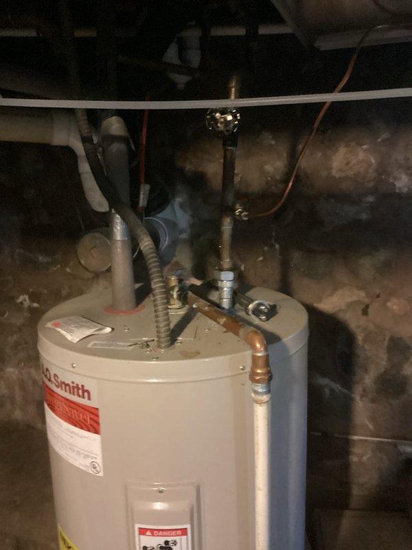 Completed on-site assessment for water heater replacement in basement utility area. Evaluated existing A.O. Smith water heater installation, documenting current unit specifications, plumbing connections, and venting configuration. Photographed water heater with all visible manufacturer labels, safety warnings, and technical specifications for estimate preparation. Assessed copper supply line connections, brass fittings, flexible connectors, PVC venting system, and shutoff valve accessibility at top of unit. Inspected installation environment including concrete floor conditions, clearance requirements, and existing drain valve location. Documented all necessary measurements and connection points to provide accurate replacement estimate for comparable or upgraded water heater unit installation.