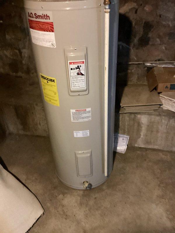 Completed on-site assessment for water heater replacement in basement utility area. Evaluated existing A.O. Smith water heater installation, documenting current unit specifications, plumbing connections, and venting configuration. Photographed water heater with all visible manufacturer labels, safety warnings, and technical specifications for estimate preparation. Assessed copper supply line connections, brass fittings, flexible connectors, PVC venting system, and shutoff valve accessibility at top of unit. Inspected installation environment including concrete floor conditions, clearance requirements, and existing drain valve location. Documented all necessary measurements and connection points to provide accurate replacement estimate for comparable or upgraded water heater unit installation.