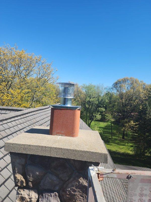Completed installation of chimney liner system for HVAC equipment. Extended 4" hard pipe through chimney structure and installed new metallic chimney cap with flue pipe penetration on brick chimney. Installed 4x6 IVC liner for water heater venting through basement wall penetration, securing flexible aluminum ductwork with proper mounting hardware and sealing all wall openings with appropriate materials to ensure code-compliant installation and proper draft operation.
