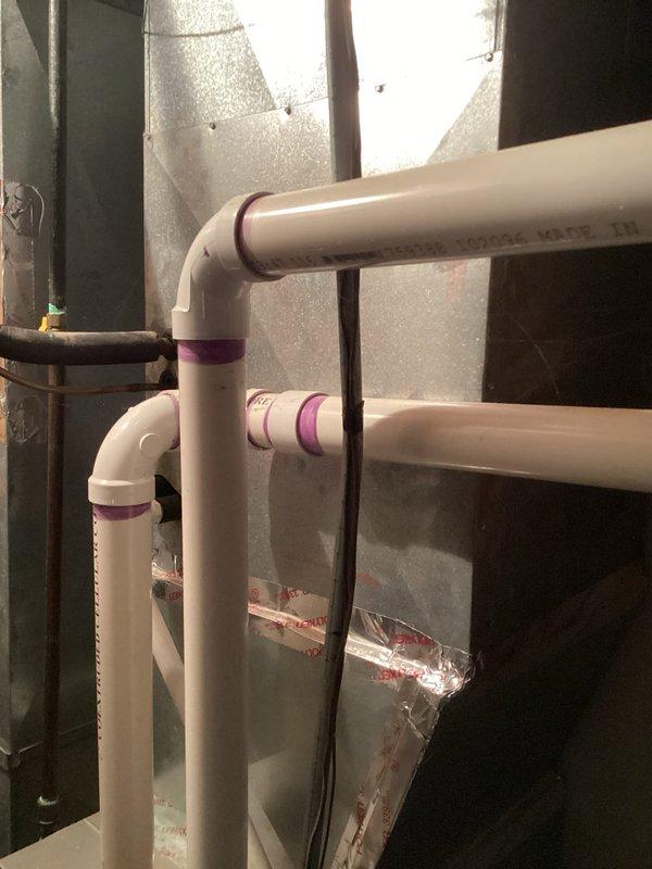 Conducted comprehensive site assessment of existing outdoor air conditioning condenser unit for full system replacement estimate. Unit showed significant weathering and discoloration, indicating age-related deterioration. Evaluated current installation including electrical connections, refrigerant line set configuration, condensate drainage system with white PVC piping and purple-primed joints, and existing concrete pad foundation. Documented equipment specifications, existing ductwork connections, and all associated plumbing and electrical components. Photographed unit positioning under pergola structure, clearance requirements, and surrounding landscape features including decorative rock border. Assessed accessibility for replacement equipment installation and verified electrical service panel location for proper disconnect sizing.