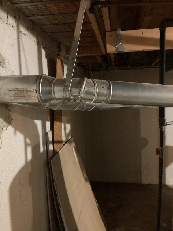 Provided estimate for replacement of 10-year-old residential water heater with larger gallon capacity located in basement utility area. Assessed existing unit with standard copper piping connections and proper venting, documented current installation conditions including exposed ductwork and mechanical systems in unfinished basement space.