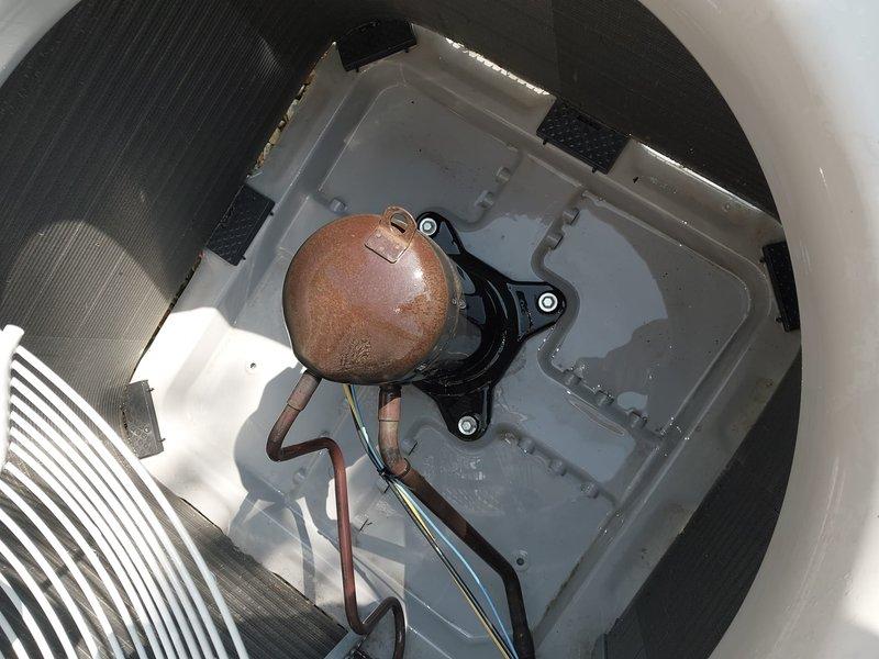Completed routine cooling system maintenance and tune-up on HVAC unit. System inspected, tested, and confirmed operational with all components functioning within normal parameters. Documented equipment condition with photographic evidence showing auxiliary drainage components including sump pump assembly with visible aging and surface oxidation on float mechanism and associated piping, though drainage system remains functional at time of service.