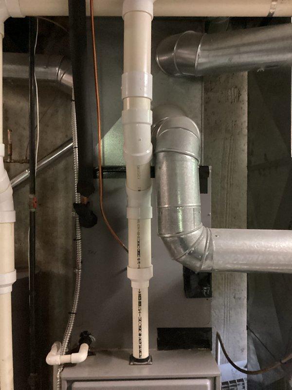 Completed air conditioning replacement estimate for residential property. Assessed existing furnace installation in basement utility area, including gray metal furnace unit with associated ductwork, PVC drainage and venting systems, and surrounding mechanical components. Documented current HVAC system configuration, ductwork layout with metallic elbow joints, white PVC piping for condensate drainage, copper tubing, and flexible conduit installations. Evaluated equipment placement, accessibility for future replacement, and compatibility with existing infrastructure including water heater proximity and Skuttle humidifier integration. Photographed mechanical room setup to provide comprehensive documentation for replacement system specifications and installation planning.