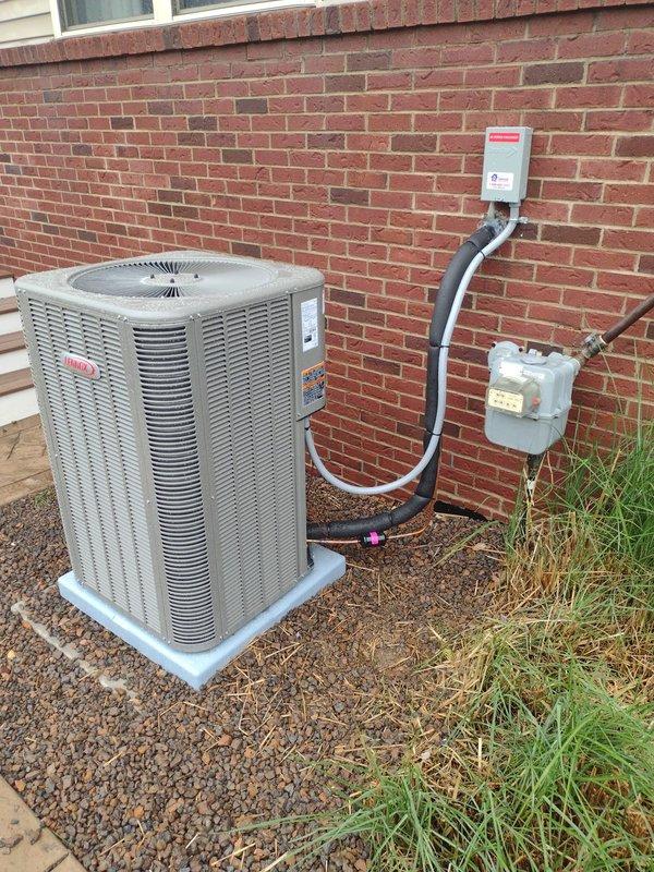 Completed full HVAC system installation including Lennox furnace, air conditioning condenser unit, and whole-home humidifier. The outdoor condenser unit was positioned on a concrete pad with proper refrigerant line routing to wall-mounted disconnect box, and all components were tested and verified operational with flame sensor properly mounted and functioning.