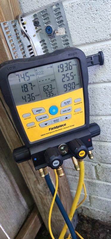 Completed comprehensive cooling season maintenance on residential air conditioning system. Connected digital manifold gauges and recorded operating pressures and temperatures, verifying refrigerant charge and system performance within manufacturer specifications. Inspected outdoor condensing unit, noting moderate weathering and rust accumulation on cabinet components and base pan with debris present; cleaned accessible areas and confirmed all mechanical components operational.