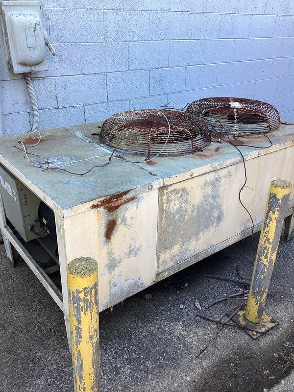 Completed estimate for HVAC system replacement at commercial facility where existing air conditioning unit had been previously removed. Assessed platform location above office area and evaluated installation requirements for new condensing unit on side of building. Documented existing deteriorated equipment showing extensive rust damage, weathered components, and corroded mounting hardware requiring complete system replacement.
