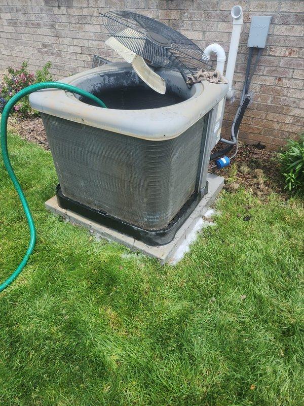 Repositioned air conditioning condenser unit that had shifted off its concrete pad and performed complete system maintenance including coil cleaning and operational inspection. Unit was leveled on pad, condenser coils were thoroughly cleaned with water spray to remove accumulated debris, and all refrigerant lines and electrical connections were verified secure and functioning properly.