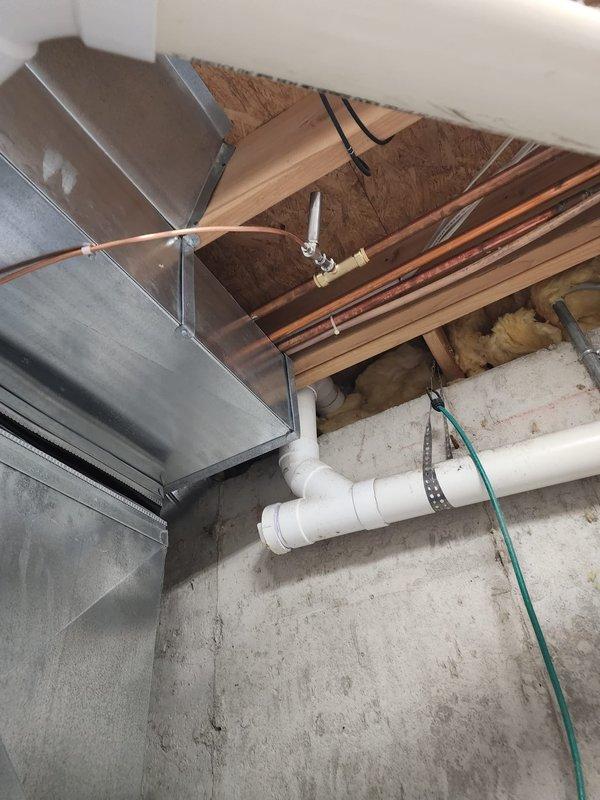 Completed installation of Lennox air conditioning system and humidifier unit in residential basement mechanical room. Installed refrigerant lines with brass fittings and proper mounting brackets, routed through ceiling joists alongside new ductwork connections. Integrated humidifier to existing furnace system with appropriate PVC condensate drainage piping, electrical connections, and grounding wire. All equipment properly mounted, secured, and tested for operational functionality. Service financing documentation completed and identification verified on file.