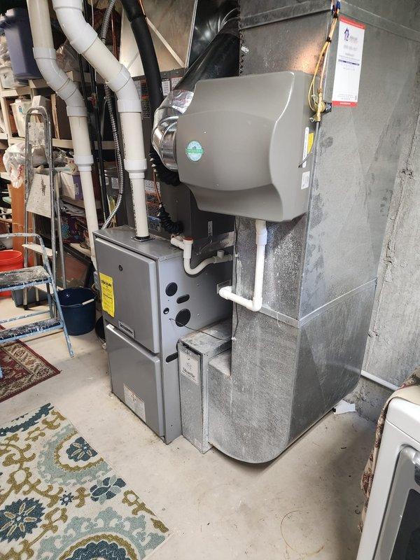 Completed installation of Lennox air conditioning system and humidifier unit in residential basement mechanical room. Installed refrigerant lines with brass fittings and proper mounting brackets, routed through ceiling joists alongside new ductwork connections. Integrated humidifier to existing furnace system with appropriate PVC condensate drainage piping, electrical connections, and grounding wire. All equipment properly mounted, secured, and tested for operational functionality. Service financing documentation completed and identification verified on file.