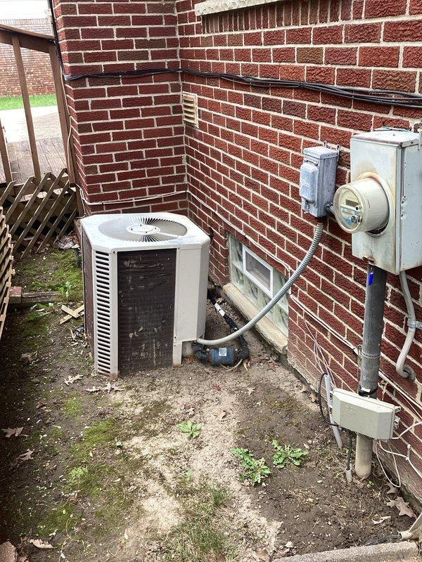 Completed estimate for replacement of 25-year-old residential air conditioning system. Evaluated existing outdoor condenser unit located in side yard utility area against brick building, noting aged equipment mounted on concrete pad with refrigerant line set penetrating exterior wall. Assessed indoor furnace and air handler system in basement to determine compatibility requirements for new equipment installation. Documented current system configuration including electrical service, disconnect location, and existing ductwork connections. Provided comprehensive replacement options for complete HVAC system upgrade to improve efficiency and reliability.