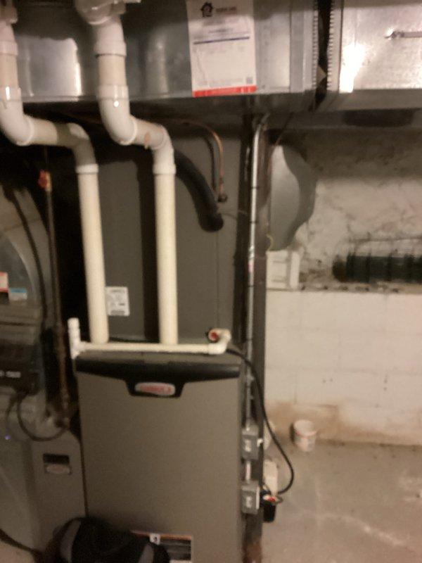 Technician diagnosed a failed condenser motor on an 11-year-old air conditioning system. Upon evaluation of the aging equipment and repair costs, provided estimate for complete HVAC system replacement. Assessment included inspection of existing furnace and air handler configuration in basement mechanical room, review of current installation with PVC condensate drainage, flexible ductwork connections, and refrigerant line routing. Replacement estimate prepared to address failed component and account for system age and overall condition.
