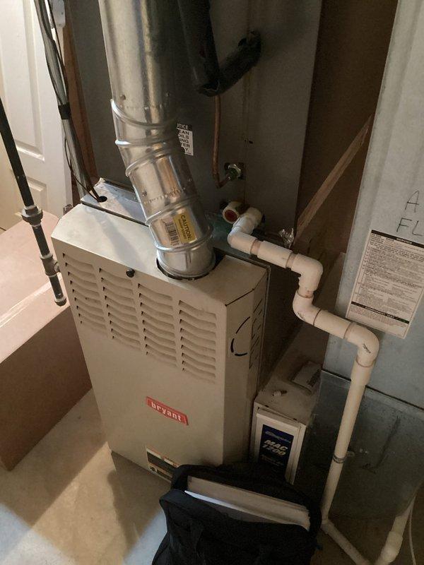 Conducted on-site evaluation for central air conditioning system replacement in residential property. Assessed existing HVAC infrastructure including Bryant furnace, water heater, and current mechanical room configuration with PVC condensate drainage and metal ductwork. Documented equipment layout, available installation space, and existing utility connections. Photographed current system components and mechanical room setup to prepare comprehensive replacement estimate for new central AC unit compatible with existing furnace and ductwork configuration.