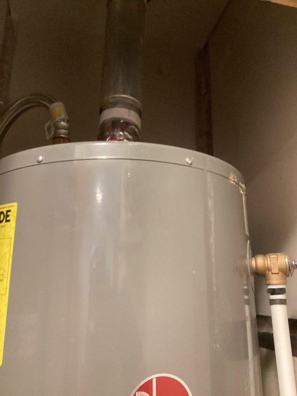 Performed on-site evaluation and estimate for replacement of 20-year-old Rheem residential water heater installed in utility closet. Documented existing unit condition, plumbing connections including gas control valve assembly, inlet/outlet configurations, and clearance constraints within confined installation space. Photographed current equipment specifications and existing piping arrangements to provide accurate replacement quote.