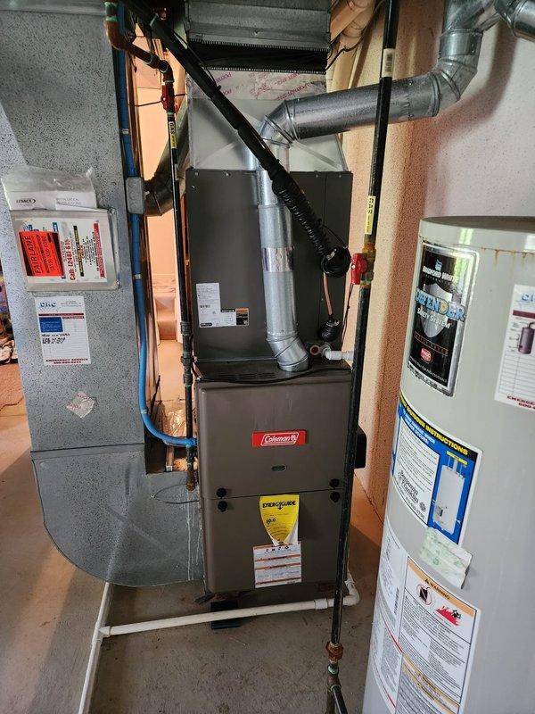 Completed installation of new Lennox air conditioning system at residential property. Installed outdoor condenser unit on concrete pad with proper electrical disconnect, ran refrigerant lines and electrical conduit along exterior brick wall, connected to existing Coleman furnace indoor air handler in basement, charged system with refrigerant, performed startup procedures, and verified proper operation of complete cooling system.