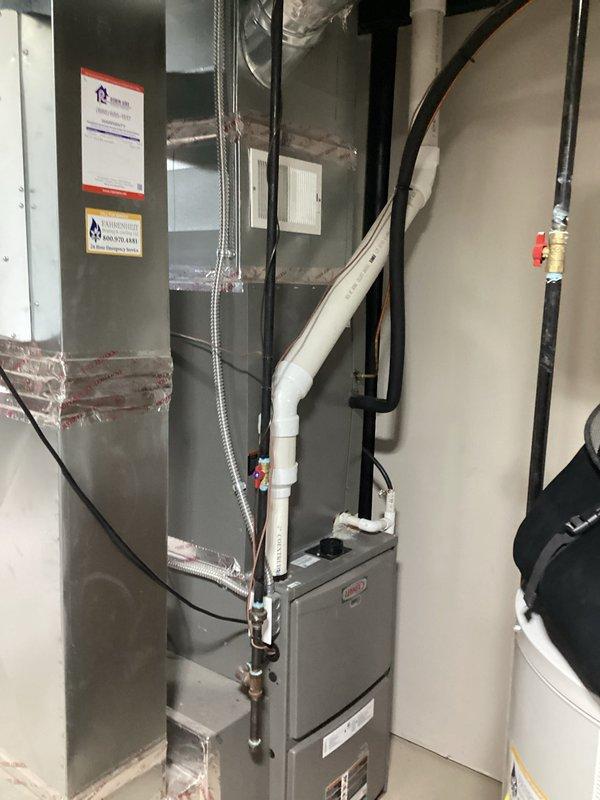 Conducted comprehensive site assessment for complete HVAC system replacement following previous repair recommendations and prior sales consultation. Evaluated existing air handler unit with reflective foil insulation wrapping, gray metal construction, and associated ductwork connections in basement utility area. Inspected current furnace installation including white PVC venting system, black condensate drainage lines, flexible metallic ductwork, and manufacturer certification labels. Documented electrical connections, control panel placement, humidifier component, and overall system configuration to develop accurate replacement estimate for complete heating and cooling system upgrade.