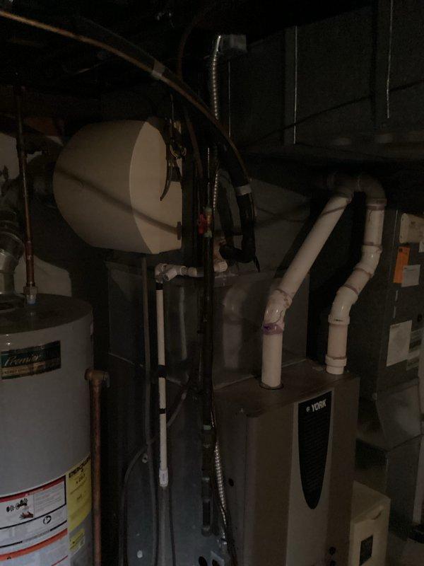 Conducted on-site assessment for furnace replacement estimate in residential basement mechanical room. Evaluated existing York brand furnace unit, documented current equipment configuration including PVC venting system, ductwork connections, and proximity to water heater. Photographed equipment layout and clearances to provide accurate replacement specifications and ensure proper sizing for new unit installation.