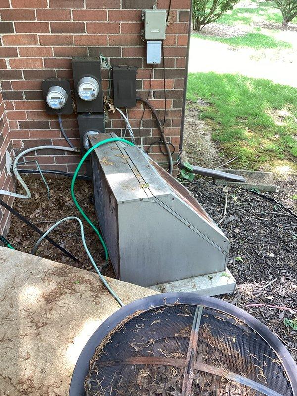 Provided estimate for complete air conditioning system replacement at condo unit with outdoor installation on back patio. Existing equipment dating from 1970 is non-operational, showing extensive corrosion, rust on fan assembly, and significant weathering throughout the unit. Assessed installation area including electrical service, meter configuration, disconnect switch, refrigerant line routing, and concrete pad condition to determine replacement specifications and equipment requirements.