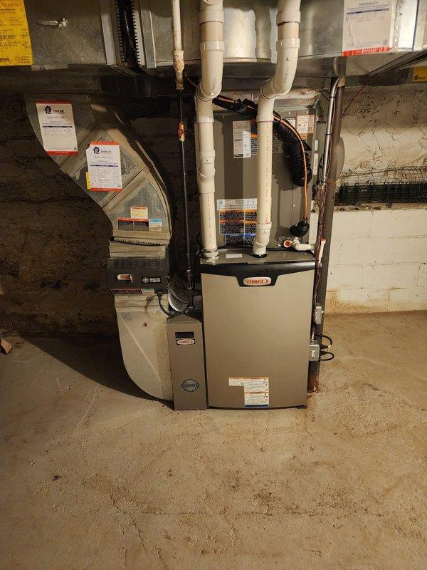 Completed full HVAC system installation in residential basement utility room. Installed new Lennox high-efficiency furnace with matching air conditioning system and S40 smart thermostat. Ran white PVC venting and condensate drain lines from furnace unit through existing ductwork penetrations. Connected refrigerant lines between outdoor condensing unit and indoor evaporator coil. Mounted condensate pump on platform at base of installation to ensure proper drainage. Integrated air handler section with existing metal ductwork system and verified all connections secure. Completed electrical wiring to furnace, air handler, and control components per manufacturer specifications. Installed and programmed S40 thermostat for optimal system performance. Tested all safety controls, verified proper airflow through supply and return ducts, and confirmed system operation in both heating and cooling modes. All equipment operational and performing to manufacturer standards upon completion.