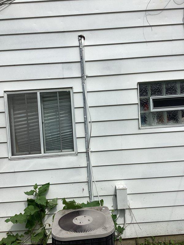 Provided estimate for complete HVAC system replacement at residential property with 20-year-old equipment currently experiencing no cooling condition. Evaluated existing outdoor condensing unit located in backyard with vegetation growth around base and indoor furnace unit positioned in utility closet with natural gas fuel source. Documented equipment locations, electrical conduit routing on exterior wall, and existing gas line connections to prepare comprehensive replacement proposal for new system installation.
