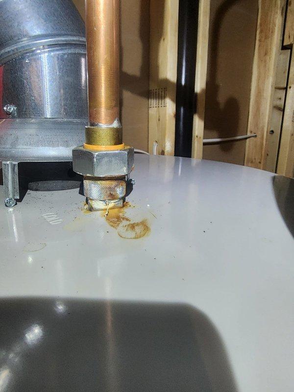 Responded to warranty call for water heater installation issues. Addressed leak at cold water inlet connection showing rust-colored staining around brass fitting and corrected improper expansion tank mounting to comply with manufacturer installation specifications. Documented completed repairs with photographs per protocol.