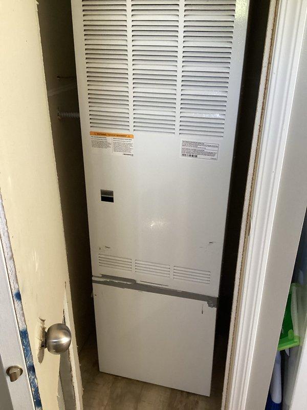 Conducted on-site assessment for HVAC system replacement at residential property. Evaluated existing furnace unit located in utility closet, documented current equipment configuration including louvered ventilation panels and existing warning labels, and captured detailed photographs of installation space to prepare comprehensive replacement estimate for customer consideration.
