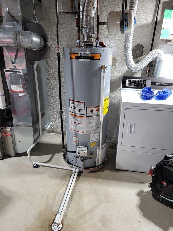 Replaced residential hot water heater and expansion tank in basement utility area. Corrected venting configuration by shortening ductwork to eliminate negative pitch and ensure proper draft. Completed all plumbing connections including copper supply lines and discharge piping. Removed old water heater from premises and transported to shop for disposal. System tested and operational upon completion.