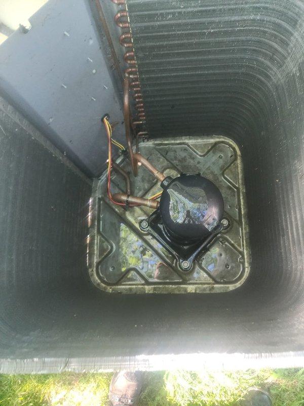 Responded to no cooling complaint on residential air conditioning system. Upon inspection, found compressor failed to operate properly. Removed top grille to access internal components and diagnosed compressor failure. Replaced defective compressor and associated copper refrigerant lines. Reinstalled unit housing and tested system operation. Unit now cooling properly and operating within manufacturer specifications. All work completed under existing labor and parts warranty coverage.