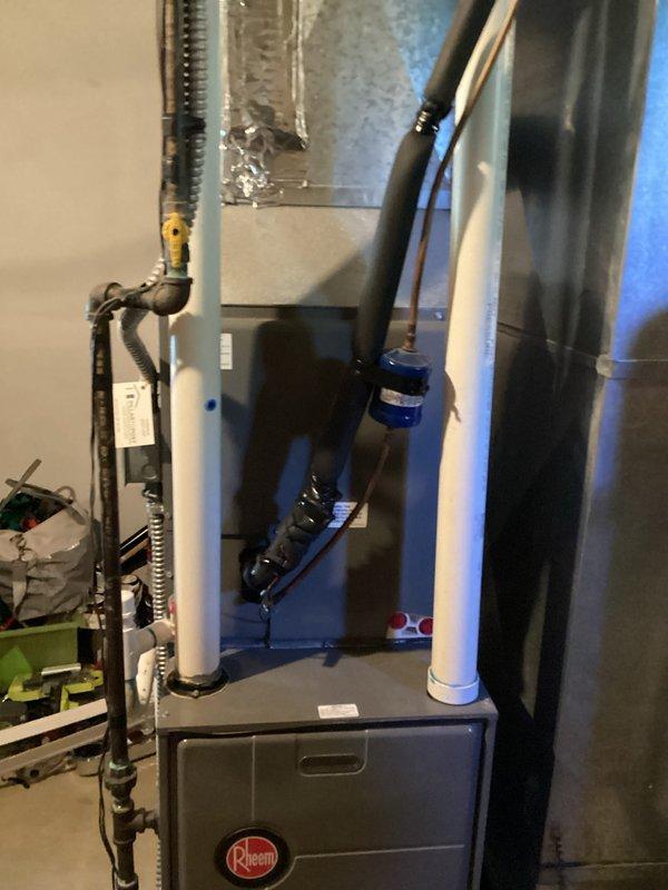 Conducted estimate for air conditioning system replacement on unit over 10 years old experiencing refrigerant leaks requiring multiple recharges. Assessed existing Rheem furnace and AC system located in basement mechanical room with PVC venting and associated ductwork. Documented current equipment configuration including air handler, plenum assembly, and condensate drainage system to provide replacement options for failing cooling system while existing heating equipment remains operational.