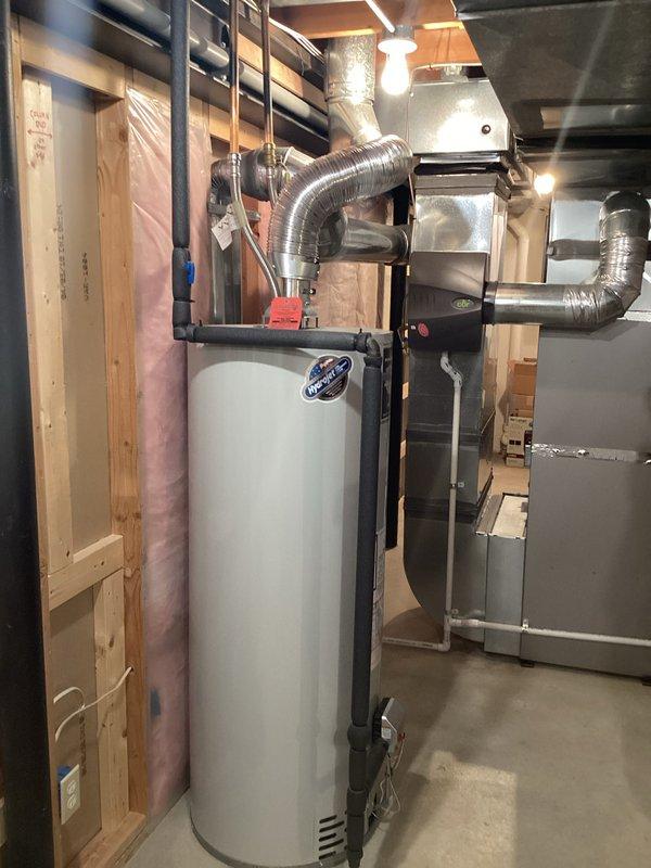Provided estimate for replacement of existing water heater manufactured in 1996. Unit is approaching end of service life at 28-29 years old and may fail within 3-5 years based on typical lifespan expectations. Documented current installation including connections, venting, and placement in basement mechanical room adjacent to HVAC equipment for replacement planning purposes.