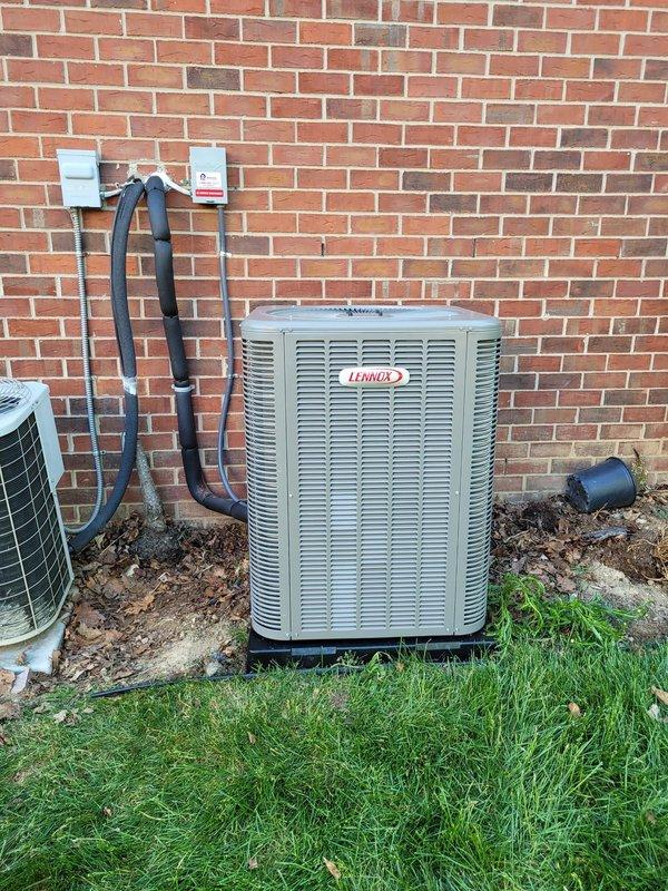 Successfully installed new Lennox air conditioning system at residential property. Unit was positioned on rubber isolation pad against exterior brick wall, with refrigerant line set properly insulated and secured to wall using appropriate mounting brackets, and electrical disconnect box installed per code requirements.