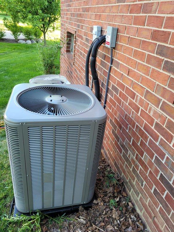 Successfully installed new Lennox air conditioning system at residential property. Unit was positioned on rubber isolation pad against exterior brick wall, with refrigerant line set properly insulated and secured to wall using appropriate mounting brackets, and electrical disconnect box installed per code requirements.