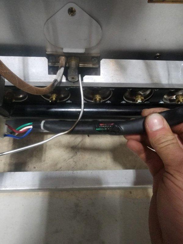 Responded to system shutdown initiated by utility company due to gas leak detected at burner assembly. Upon arrival, inspected furnace combustion chamber and identified leak at burner manifold connections. Photographed gas valve assembly, heat exchanger condition showing soot patterns and discoloration, and burner rail with brass orifices. Documented electrical connections, ignition components, and copper ground wire routing during inspection. System remains offline pending leak repair and utility company clearance for restart.