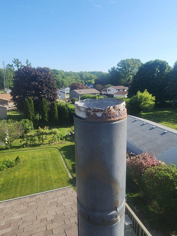Responded to service call for missing chimney cap that had blown off during recent weather event. Upon arrival, inspected metal chimney pipe and confirmed cap was completely detached with visible deterioration and rust damage to the crown area. Documented existing condition showing compromised chimney components and replaced missing cap to restore proper ventilation protection and prevent water intrusion.