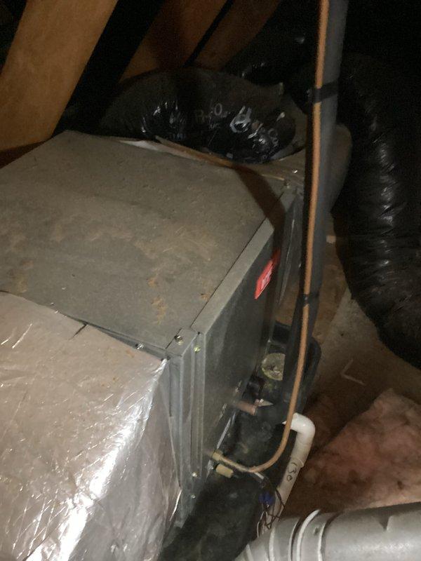 Provided estimate for complete air conditioning system replacement in attic-mounted installation. Existing gray metal air handler and associated ductwork assessed as non-operational and aged beyond serviceable life. Documented current system configuration including flexible ductwork, copper refrigerant lines, and PVC condensate drainage for replacement specifications.