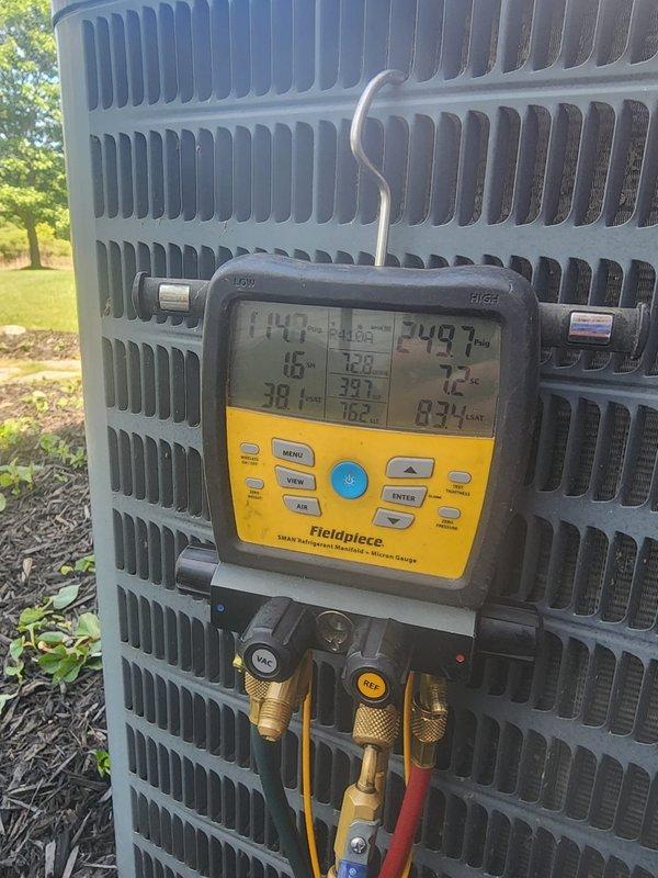 Responded to no cooling complaint on residential air conditioning system with outdoor condenser unit located at property and air handler in basement. Upon arrival, connected Fieldpiece digital gauge manifold to outdoor unit to assess system pressures and temperatures. Gauges displayed 140°F discharge temperature indicating compressor operation but potential refrigerant or airflow issues.

Inspected indoor air handler unit mounted on water heater in basement utility room. Discovered significant moisture accumulation and condensation on top of air handler cabinet and blower motor assembly, indicating restricted airflow or frozen evaporator coil condition. Water droplets and wet patches observed across metal surfaces with debris present, confirming coil freeze-up had occurred and subsequently thawed.

Diagnosed no cooling condition as result of frozen evaporator coil caused by restricted airflow. Primary contributing factor identified as dirty air filter or blocked return air pathway prev