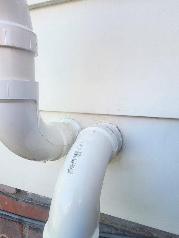 Performed AC system start-up and identified two significant holes in PVC condensate drain piping requiring immediate attention. Documented damage with photographs showing compromised pipe sections with visible openings and rust staining around wall penetrations, indicating ongoing moisture issues that could lead to water damage if not addressed.