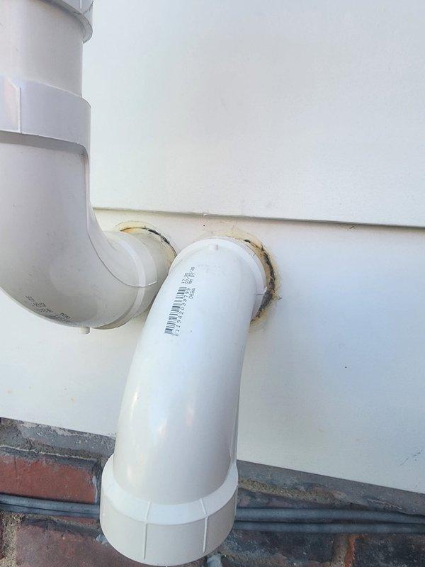 Performed AC system start-up and identified two significant holes in PVC condensate drain piping requiring immediate attention. Documented damage with photographs showing compromised pipe sections with visible openings and rust staining around wall penetrations, indicating ongoing moisture issues that could lead to water damage if not addressed.