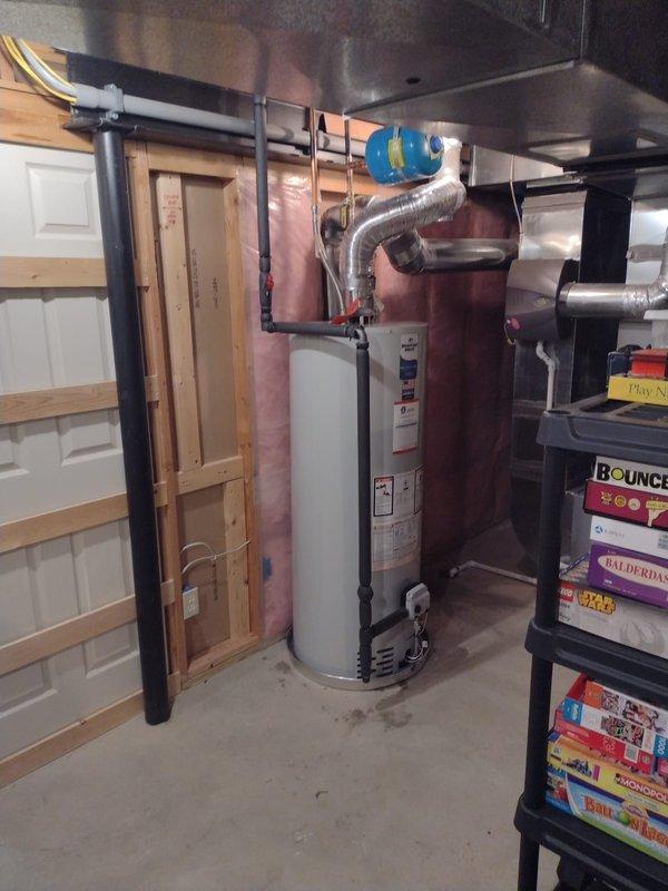 Completed installation of a 50-gallon residential tanked water heater in basement utility area. Properly configured all supply and discharge plumbing connections with black piping, installed pressure relief valve, and integrated blue pressure expansion tank with appropriate flexible connections. All work performed to code specifications with system tested and verified operational upon completion.
