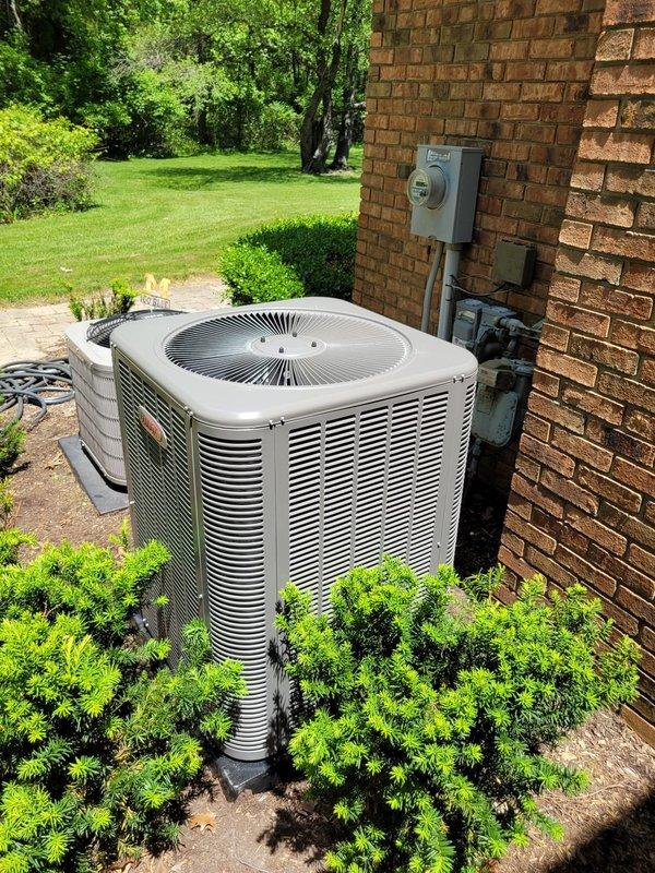 Completed installation of new Lennox air conditioning system at residential property. Unit was positioned on concrete pad adjacent to brick exterior, with refrigerant lines routed along wall to interior air handler, electrical disconnect box mounted per code requirements, and system tested for proper operation upon completion.