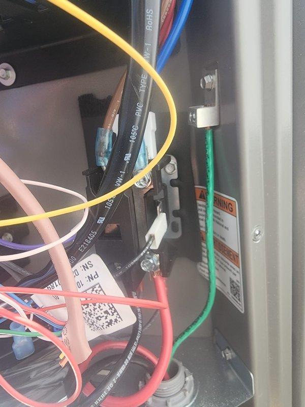 Responded to callback for AC unit producing loud buzzing noise during operation. Inspected electrical control panel and interior components, examining terminal strip connections, control board wiring, and blower assembly. All wire connections at terminal block were secure with proper gauge conductors (yellow, red, blue, green) correctly terminated. Verified control module mounting and electrical connections showed no signs of arcing or loose terminals. Checked blower motor assembly, refrigerant line routing, and mounting hardware for vibration or contact points that could generate noise. Unit operating normally at time of inspection with no buzzing detected during run cycle.