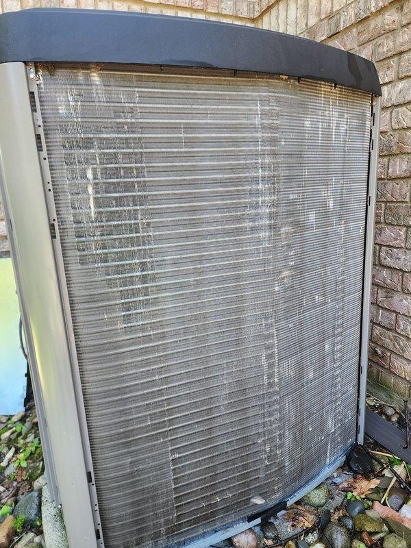 Completed comprehensive cooling system maintenance and tune-up on residential HVAC unit. System inspected outdoor condenser unit positioned against exterior brick wall, verified proper operation of all components including compressor, condenser coil, and fan assembly. Cleaned condenser coil fins through protective mesh screen, removed debris and organic matter from base of unit and surrounding area. Inspected interior air handler components within cylindrical plenum chamber, examined blower assembly and verified proper motor operation. Checked copper refrigerant line connections for secure fittings and signs of leakage. All electrical connections tested and confirmed secure. System operating within normal parameters with adequate airflow and proper temperature differential. Unit confirmed fully operational at completion of service call.