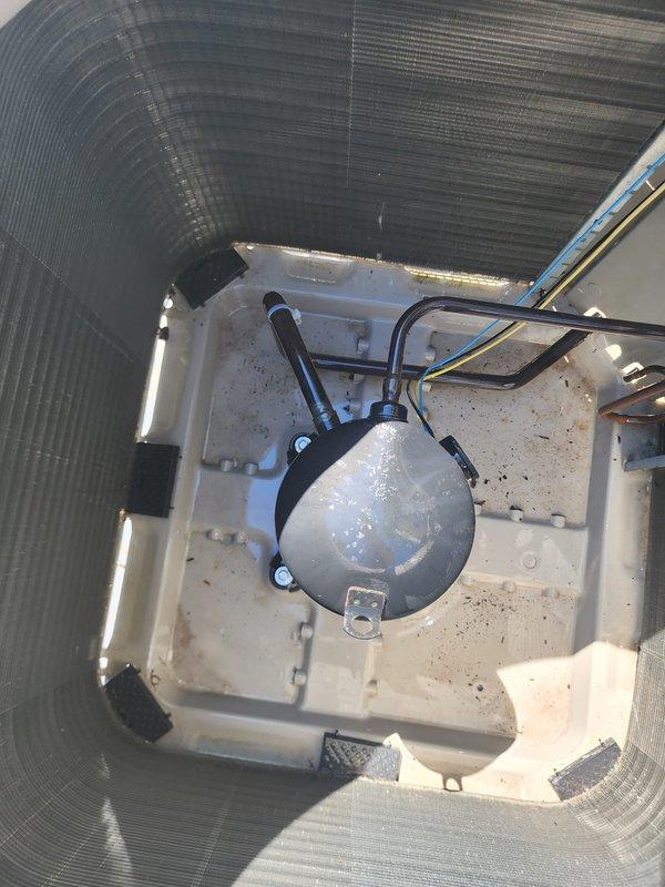 Completed scheduled maintenance on residential air conditioning system. Performed comprehensive inspection of outdoor condenser unit, noting accumulated dirt and debris on coil fins and interior components. Cleaned condenser coils, removed environmental debris from unit base and interior compartment, and inspected compressor housing, refrigerant lines, and electrical connections. System operational and cooling properly upon completion of maintenance service.