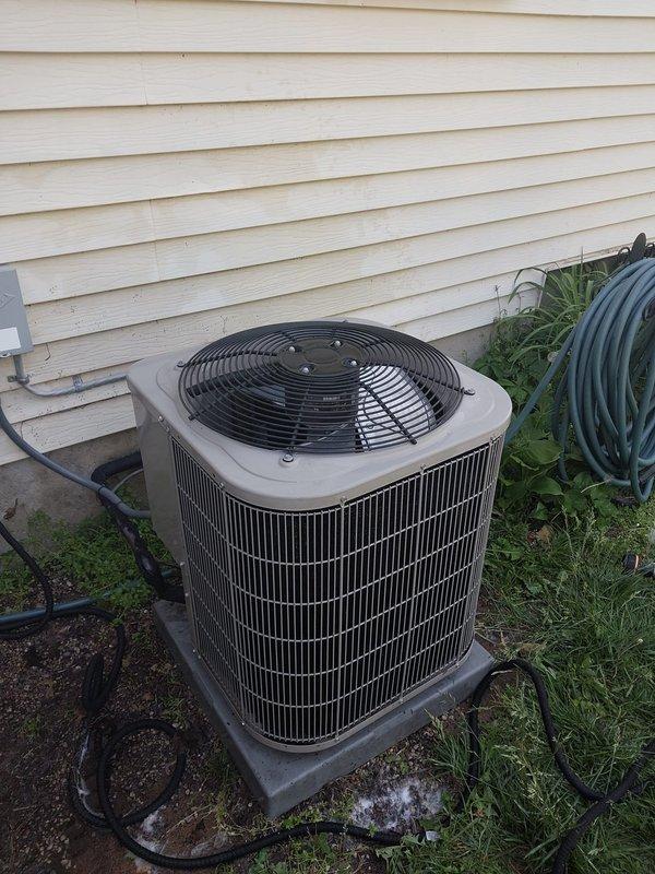 Completed scheduled AC maintenance on residential outdoor condensing unit. Performed comprehensive system inspection including visual examination of condenser coils, fan assembly, and electrical components. Unit found in operational condition with cylindrical condenser positioned on pad against exterior wall. Verified proper fan operation, checked refrigerant line connections, and inspected electrical disconnect box. Documented equipment condition with photographs showing unit placement, surrounding area, and overall system configuration. All maintenance tasks completed per manufacturer specifications and industry standards.
