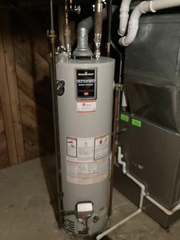 Conducted on-site assessment for hot water tank replacement in residential utility room. Documented existing gas-fired water heater installation with copper supply lines, pressure relief valve, and PVC venting connections, along with adjacent furnace system. Photographed equipment specifications, plumbing connections, and surrounding mechanical room conditions to prepare comprehensive replacement estimate for property owner's review via email.