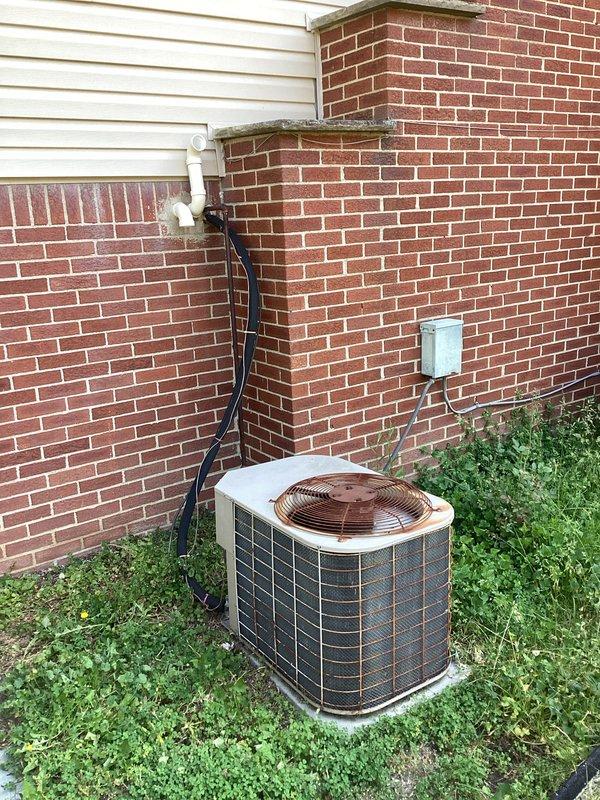 Conducted on-site evaluation for full HVAC system replacement estimate on 15-20 year old equipment with uncertain operational status. Assessed existing natural gas furnace installation located in basement with humidifier and ductwork configuration, along with outdoor air conditioning condenser unit positioned on concrete pad against brick exterior wall. Documented current system components, electrical connections, ventilation piping, and installation conditions to provide comprehensive replacement recommendations for complete heating and cooling system.