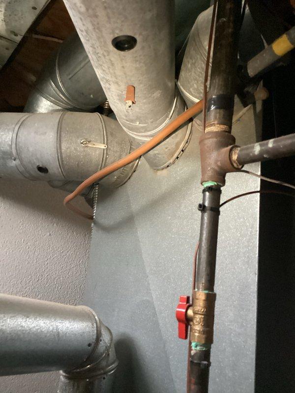Conducted estimate for full HVAC system replacement and standalone A/C replacement options. Upon inspection, found existing system operating with low R22 refrigerant charge, indicating potential leak in refrigerant circuit. Documented current equipment configuration including aging ductwork system, water heater, and associated mechanical components showing signs of corrosion and wear. Photographed existing infrastructure to support replacement recommendations, capturing deteriorated piping with visible oxidation, aged metal ductwork with surface discoloration, and overall system layout in basement utility area. Provided customer with comprehensive replacement options addressing refrigerant deficiency and aging equipment concerns.