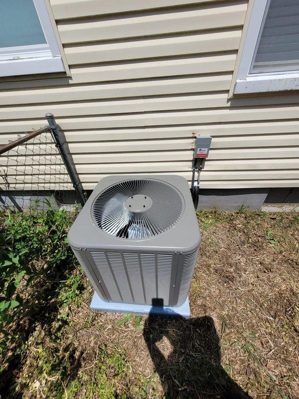 Completed installation of Lennox air conditioning condenser unit at residential property. Unit was positioned on concrete pad against exterior wall with proper electrical disconnect box mounted and refrigerant lines run through siding into home. System was tested and verified operational upon completion.
