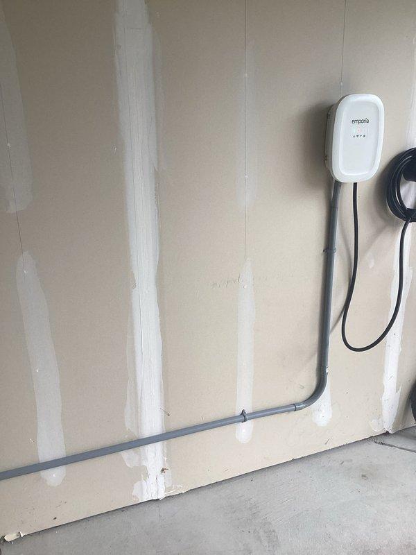 Installed a dedicated 240-volt, 20-amp circuit with copper conductors originating from the existing main service panel to power a Level 2 EV charging station. The customer-supplied Emporia charger was hardwired and mounted on the right side of the garage wall. Circuit cabling was routed through gray PVC conduit along the garage wall to the charger location, ensuring a clean and code-compliant installation. A new circuit breaker was installed in the main panel, and all connections were properly terminated and secured. The installation was completed with permit approval and passed final inspection.
