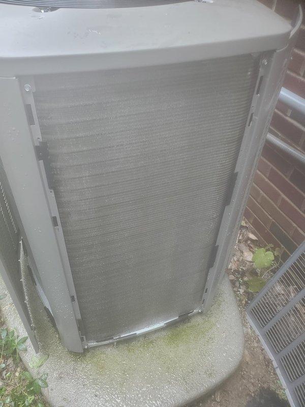 Completed scheduled cooling season maintenance on residential HVAC system. Performed comprehensive tune-up inspection of outdoor condenser unit, which was found to be operational. Unit exterior showed typical environmental accumulation on coil fins and surfaces. Documented equipment condition with photographs showing condenser installation on concrete pad in side yard location between brick wall and lattice screening. System confirmed working properly at time of service visit.