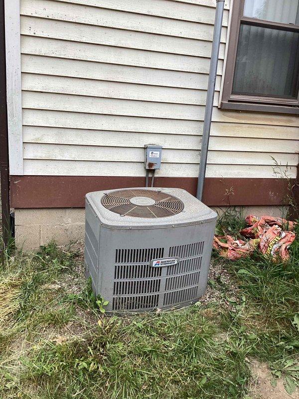 Completed comprehensive estimate for full air conditioning system replacement at residential property. Assessed existing Robin Aire furnace installation in basement utility area with current ductwork configuration including metallic flex duct connections and galvanized metal supply runs. Evaluated outdoor condensing unit positioned against exterior wall with existing electrical disconnect and conduit routing. Documented equipment specifications, spatial constraints, and electrical infrastructure to provide customer with replacement options for complete HVAC system upgrade.